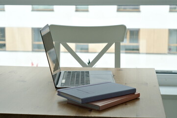 light table with chairs with laptop. workspace on kitchen table. notepads