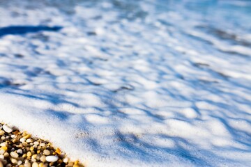Snow covering pebbles on the seashore