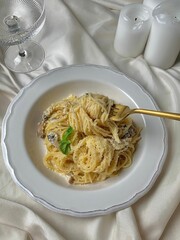 Vertical shot of spaghetti in a white plate on a table