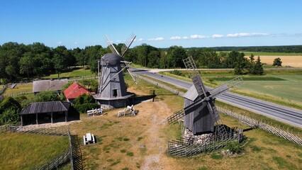 Aerial shot of windmills in the field next to the road and trees