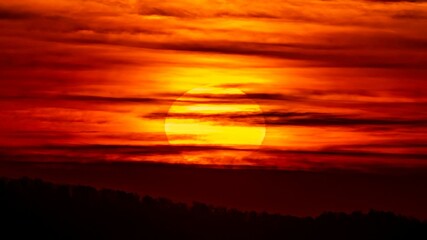 Beautiful view of a setting sun in a red-illuminated sky, can be used for wallpaper