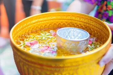 Songkran culture in Thailand during the summer, flowers, water in a bowl, perfume, gold, bright colors, water with flowers
