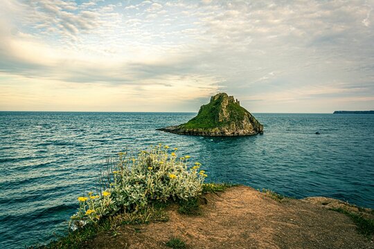 Landscape scene of Thatcher Rock in Torquay, Uk in the sea with gray sky