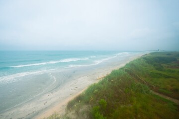 Aerial view of the green shore and turquoise sea.