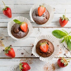 Schokolademuffins mit frischen Erdbeeren.
Nahaufnahme, Vogelperspektive, Vintage Umgebung