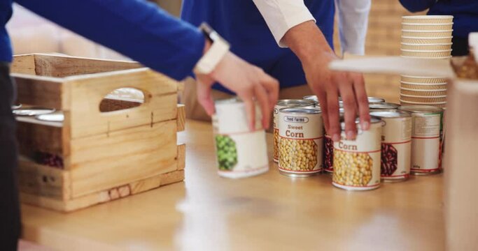 Hands, volunteer and aid with food cans for ngo, donations or outreach society and preparing package. Community service, giving in collaboration for charity, donation project or teamwork with people