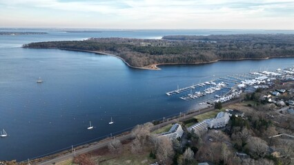 Drone shot of a scenic sea with boats on its harbor and houses on the coast, cool for background