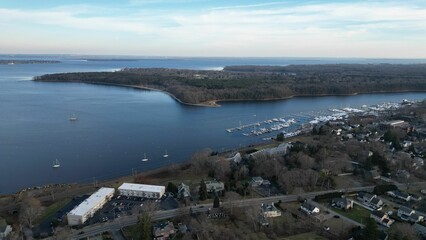 Drone shot of a scenic sea with boats on its harbor and houses on the coast, cool for background