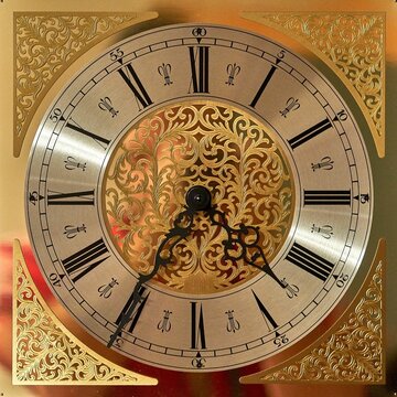 Closeup of an antique golden clock with roman numerals and black hands