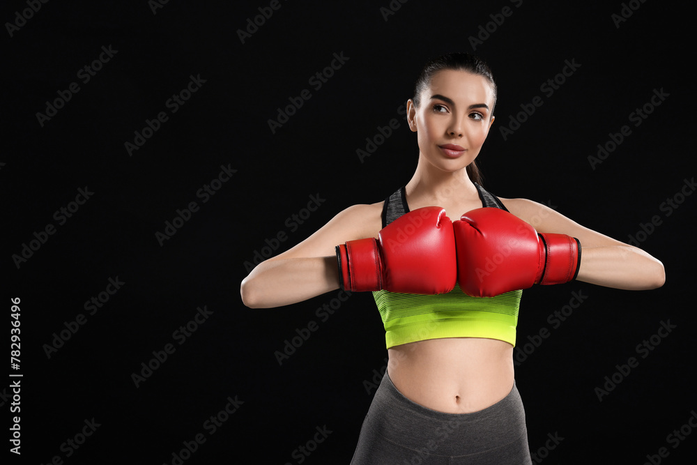 Canvas Prints Portrait of beautiful woman in boxing gloves on black background. Space for text