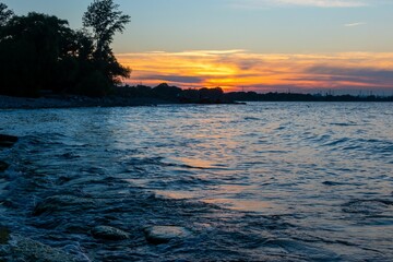 Obraz premium Beautiful bright sunset sky over a blue lake