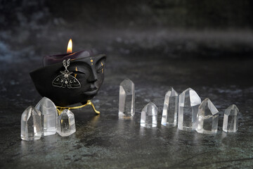 witchcraft bowl with candle and amulet, quartz crystals on dark abstract  background. Magic Crystal...