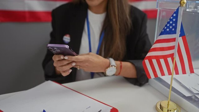 Hispanic woman uses smartphone at a us electoral polling station with american flag