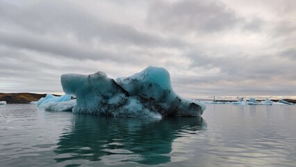 Floating icebergs in the water against a cloudy sky