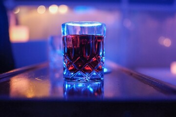 Closeup shot of a glass of whiskey with cola on the bar on a blurred background
