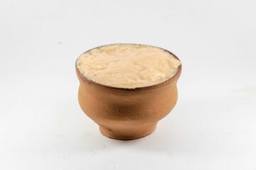 Bowl of Mishti Laal Doi or dahi or Bengali sweet curd isolated on white background