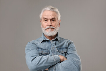 Senior man with mustache on grey background