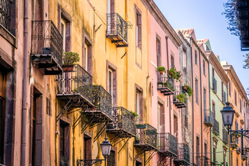 Fototapeta na wymiar Balconies and windows on old buildings in italian town in Sardinia.