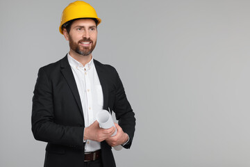 Architect in hard hat with draft on gray background, space for text