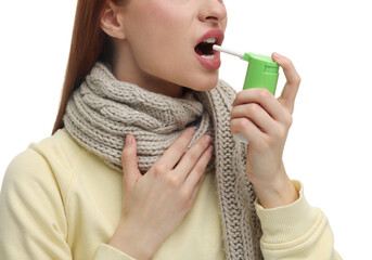 Young woman with scarf using throat spray on white background, closeup - obrazy, fototapety, plakaty