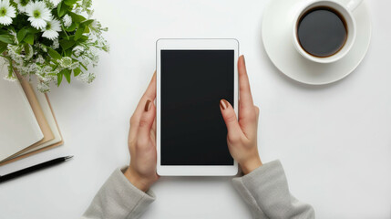 White Background. Top view image of a woman using a digital tablet at her desk close up of young female's hands on white desk. Top view of woman holding tablet.