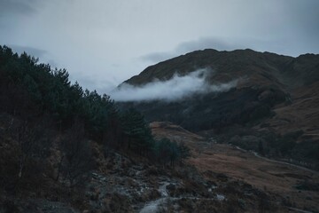 Beautiful view of clouds over the mountains in Glenfinnan hamlet in Scotland.