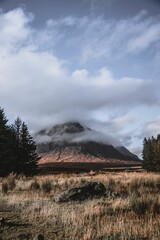 Vertical shot of the Buachaille Etive Mor covered in clouds in Glencoe