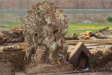 Broken sculpted statue of lord Ganesh on the street side.