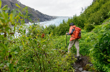Fototapeta na wymiar People carrying ice crampons on their backpacks, hiking towards Exit Glacier. Kenai Fjords National Park. Alaska.
