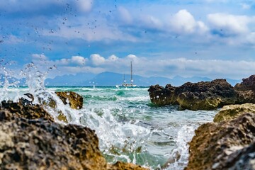 Landscape of a rocky shore surrounded by the sea under a cloudy sky in Mallorca, Spain