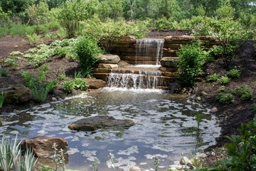 Small cascade waterfall and river surrounded by greenery