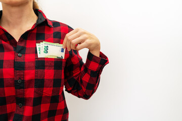 Female person showing money euro bills in her pocket of shirt.
