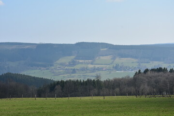 Obraz premium Large green field at the foot of the hills