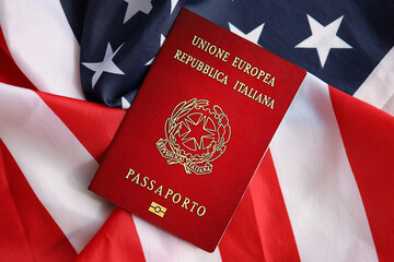 Italian passport on United States national flag background close up. Tourism and diplomacy concept