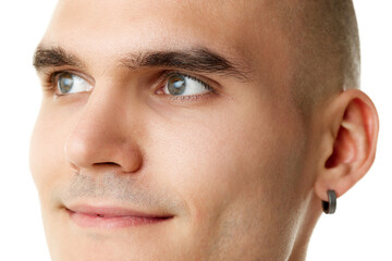 Close-up of handsome young smiling man with spotless face, thick brows and looking aside isolated on white studio background. Concept of skincare, male beauty, wellness, cosmetics, self-care
