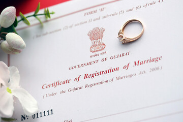 Indian Certificate of registration of marriage blank document and wedding ring on table close up