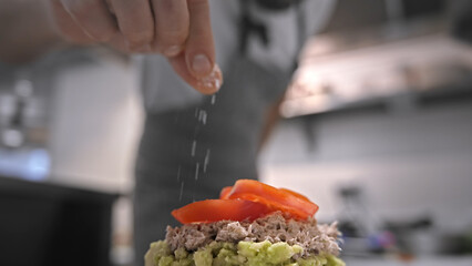 Male head chef prepare tasty fresh bruschetta dish close up. Man cook meal restaurant kitchen. Young adult person work cafe cuisine. Guy make diet lunch food. Culinary worker job. Cookery staff recipe