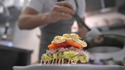 Male head chef prepare tasty fresh bruschetta dish close up. Man cook meal restaurant kitchen. Young adult person work cafe cuisine. Guy make diet lunch food. Culinary worker job. Cookery staff recipe - obrazy, fototapety, plakaty