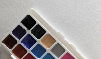 Close up of a palette of paint. White paper. 