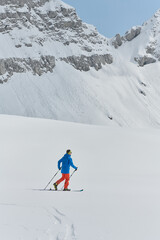 Fototapeta na wymiar A Skier Scales a Treacherous Alpine Peak