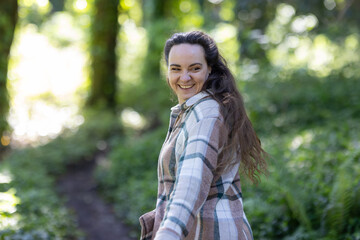 Young Woman smiling and Walking Down Path in Woods