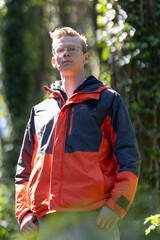 Man in Red and Blue Jacket Standing in Woods