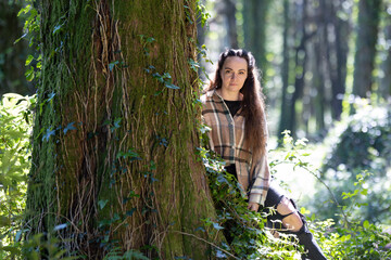 Woman Sitting Next to Tree in Forest