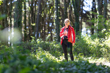 Woman in a Red Jacket Walking Through a Forest
