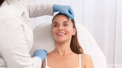 Close-up. Before the procedure for facial contouring or plastic surgery, the cosmetologist makes markings on the patient’s face. Time to prepare for a cosmetic procedure.