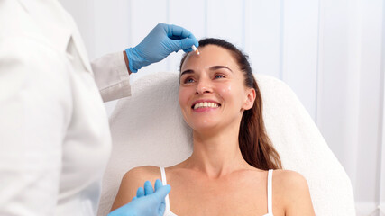 Close-up. Before the procedure for facial contouring or plastic surgery, the cosmetologist makes...
