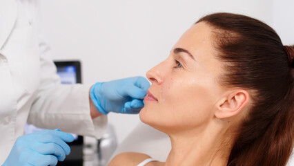 Close-up. Before the procedure for facial contouring or plastic surgery, the cosmetologist makes...