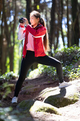 Woman photographer in Red Jacket Doing Yoga Pose