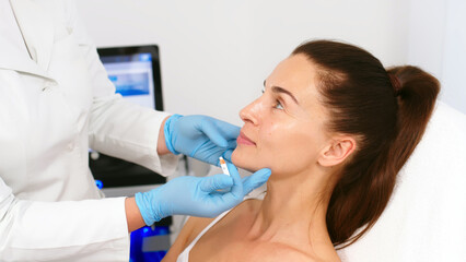 Close-up. Before the procedure for facial contouring or plastic surgery, the cosmetologist makes markings on the patient’s face. Time to prepare for a cosmetic procedure.