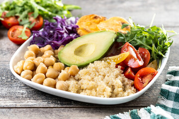 Healthy salad with avocado,lettuce,tomato and chickpeas on wooden table